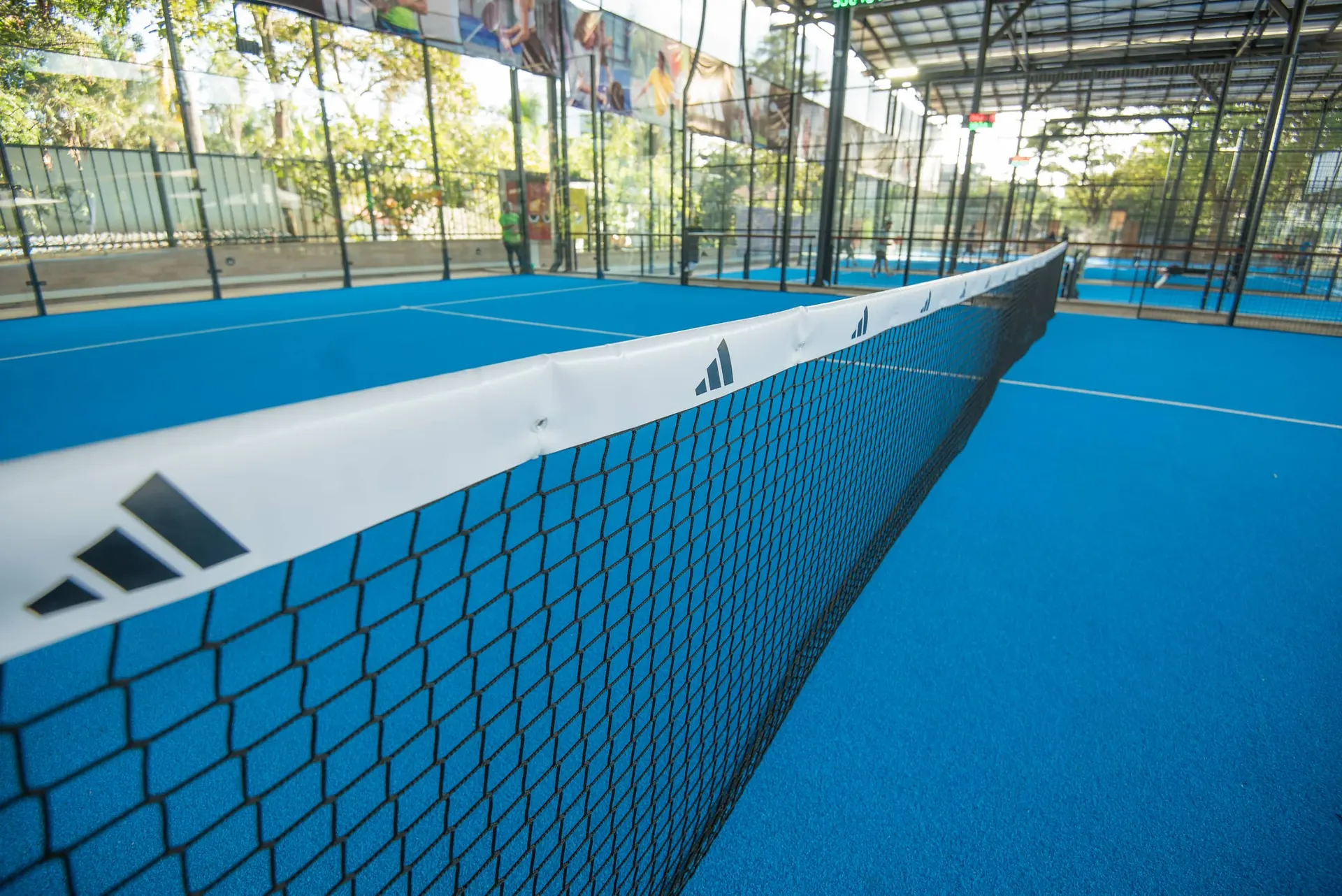 Detail of a padel court net against the blue playing surface.