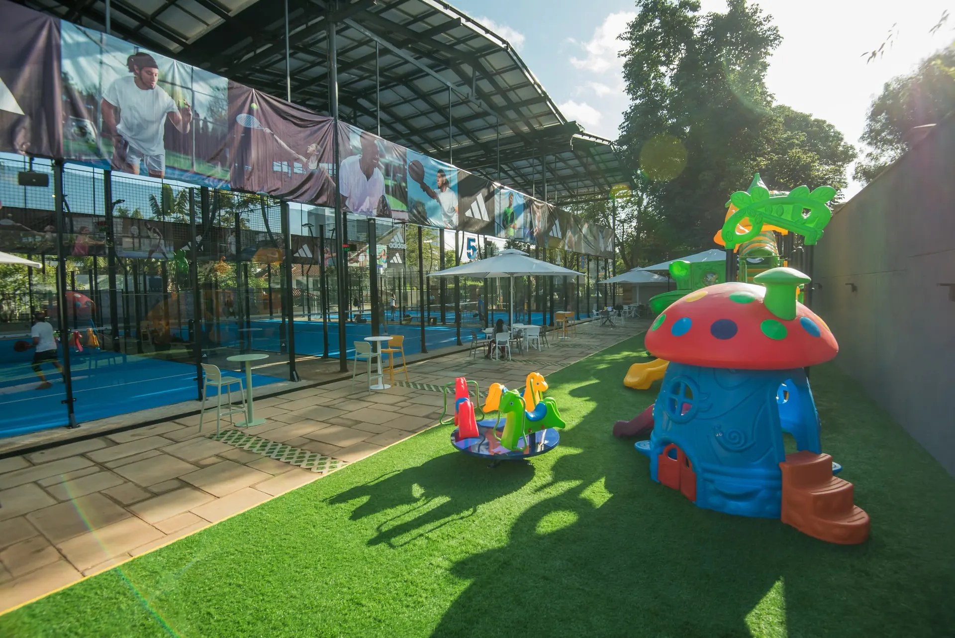 Landscaped social terrain linking dining, play and the courts.