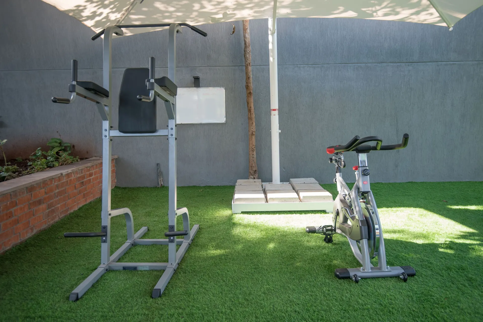 Outdoor training equipment on turf beside the courts.