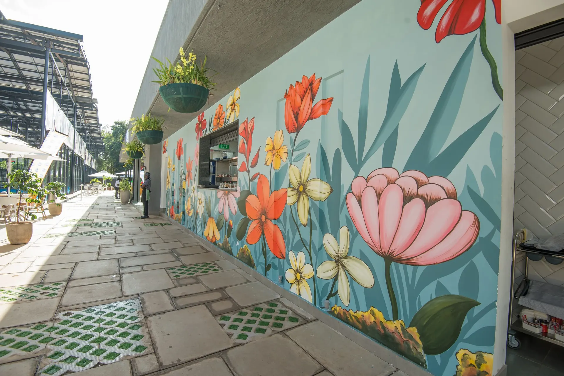A floral mural running along the covered walkway.