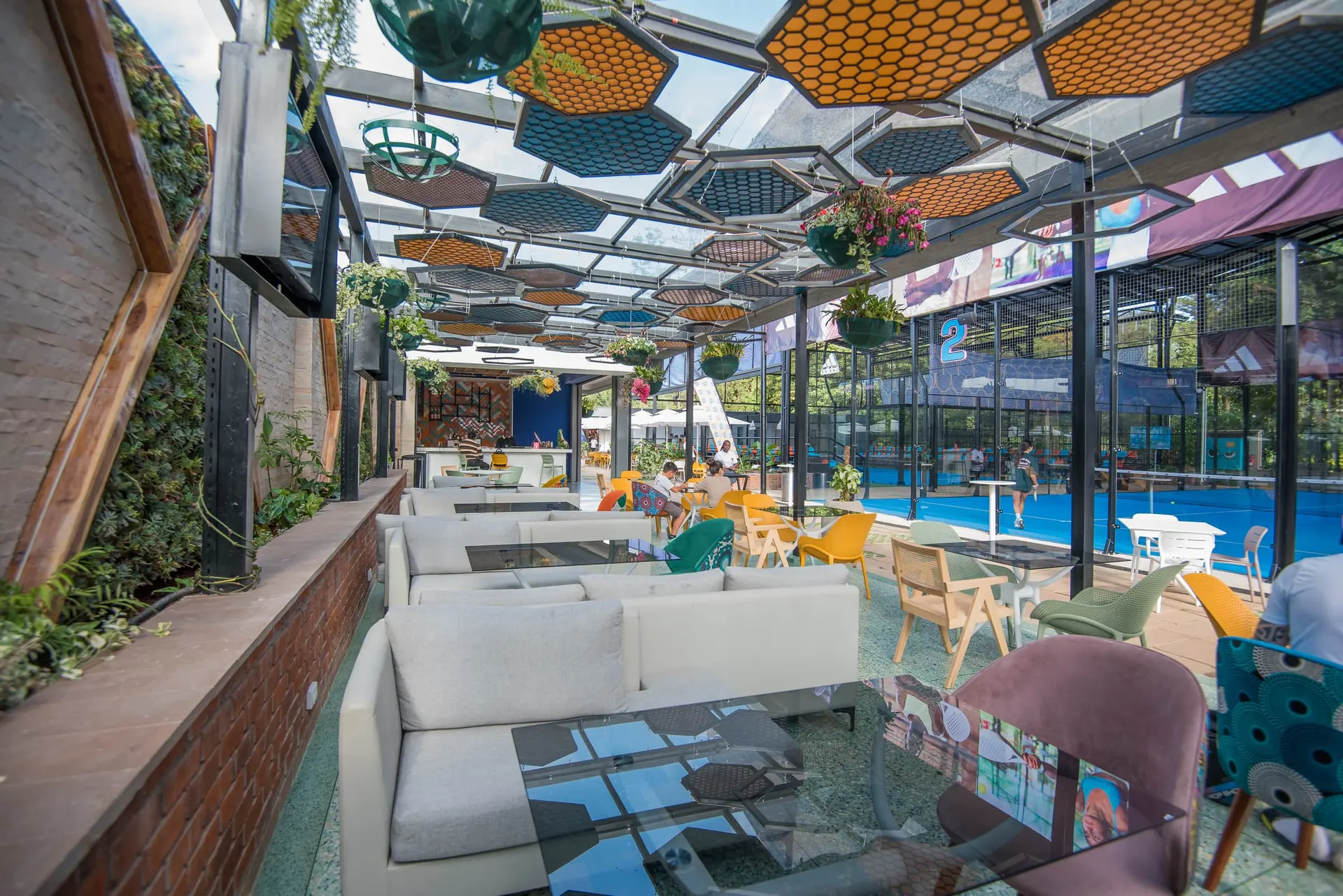 The social lounge under a patterned hexagonal canopy, opening to the pool.